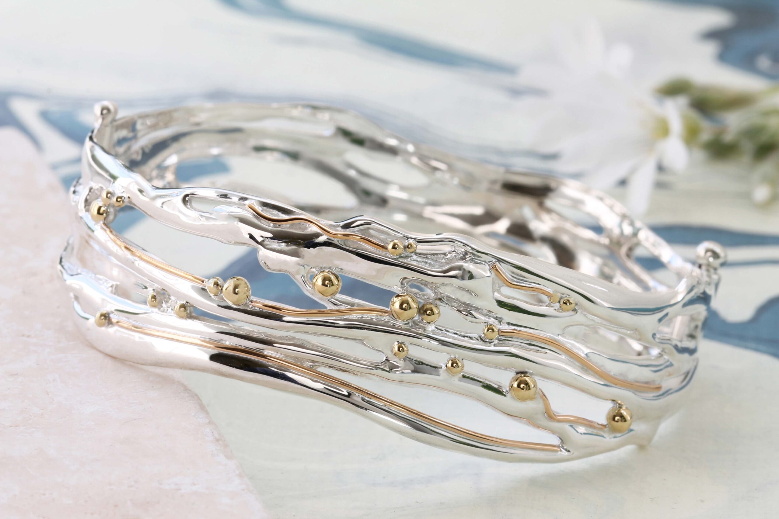 A Banyan Jewellery sterling silver organic waves bangle with delicate gold details